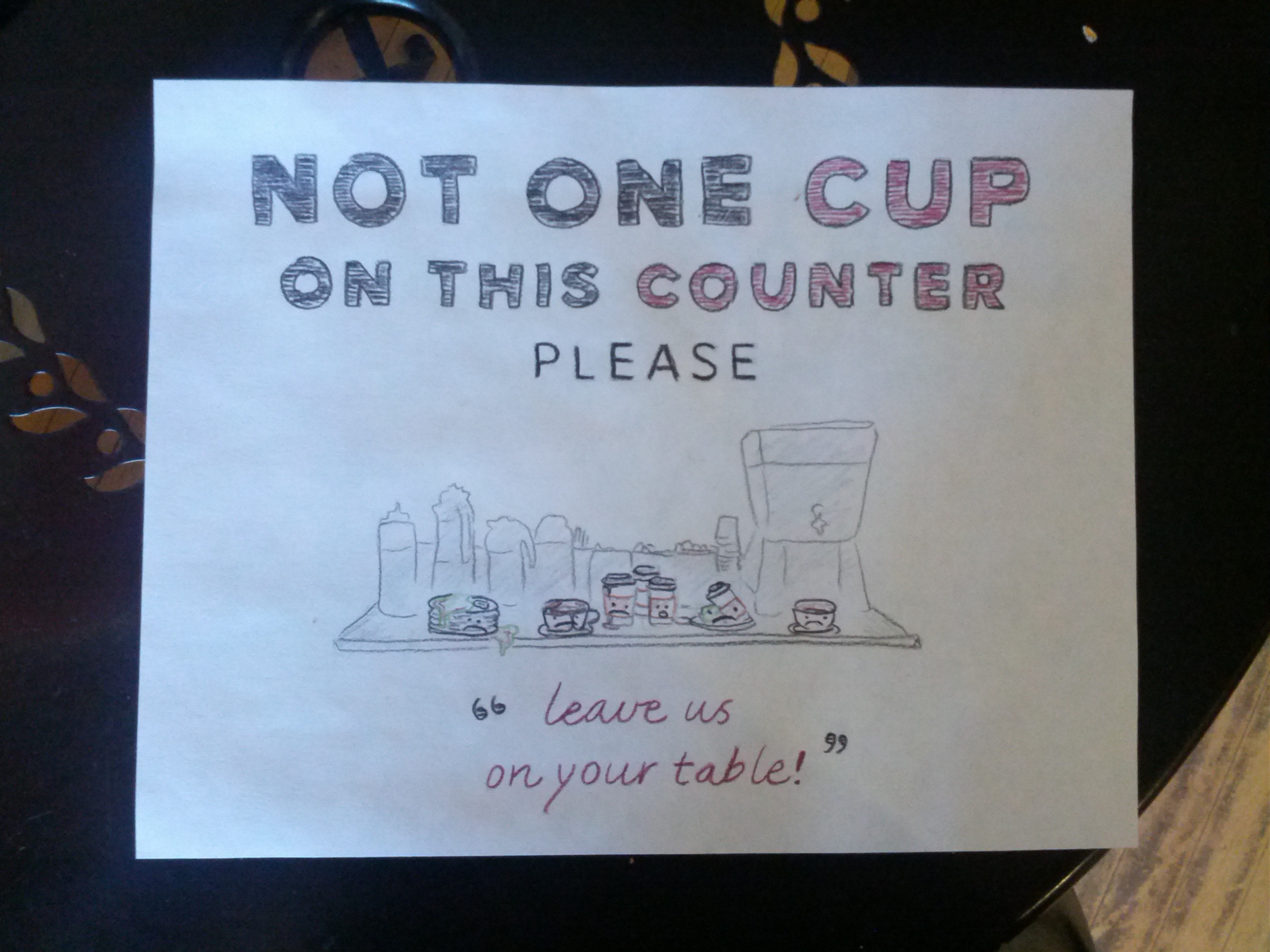 Not one cup on this counter please. (A colletion of sad looking cups and plates sit on the forbidden counter, saying 'Leave us at your table.')