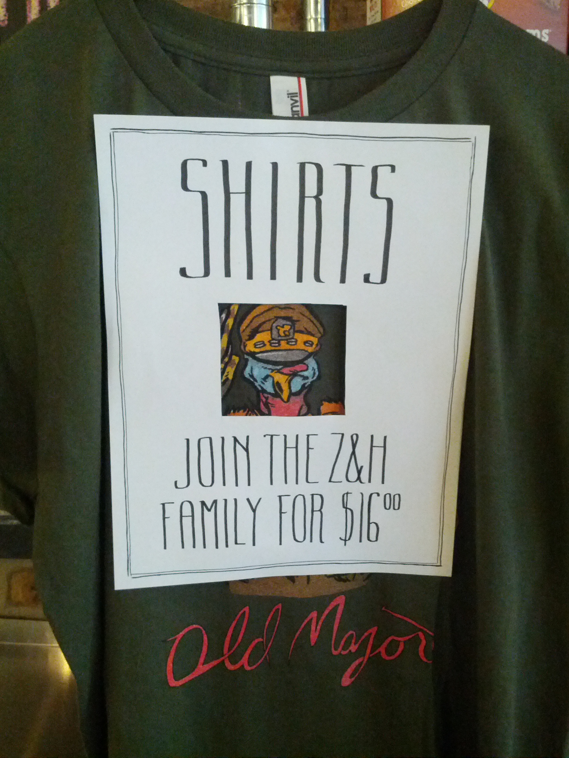 Shirts! Join the Z&H family for $16.00. (The sign is placed over one of the shirts with a frame cut out for the t-shirt's front: a turkey dressed up as an army major.)